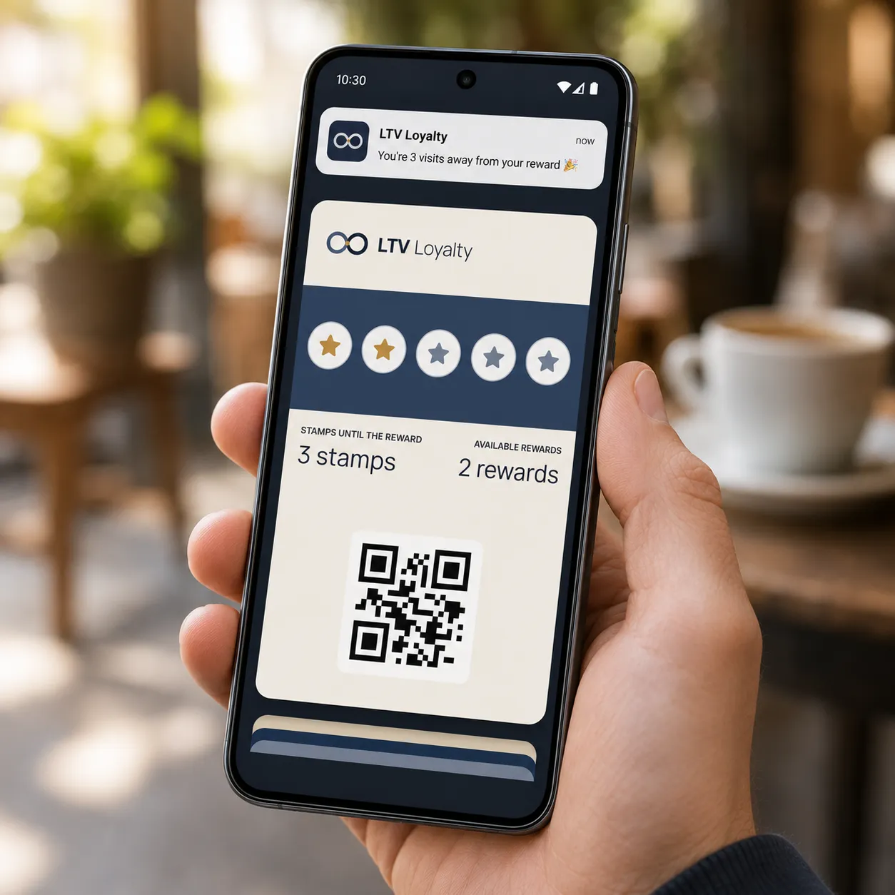 Customer holding a phone showing the LTV Loyalty digital stamp card and QR code at a cafe